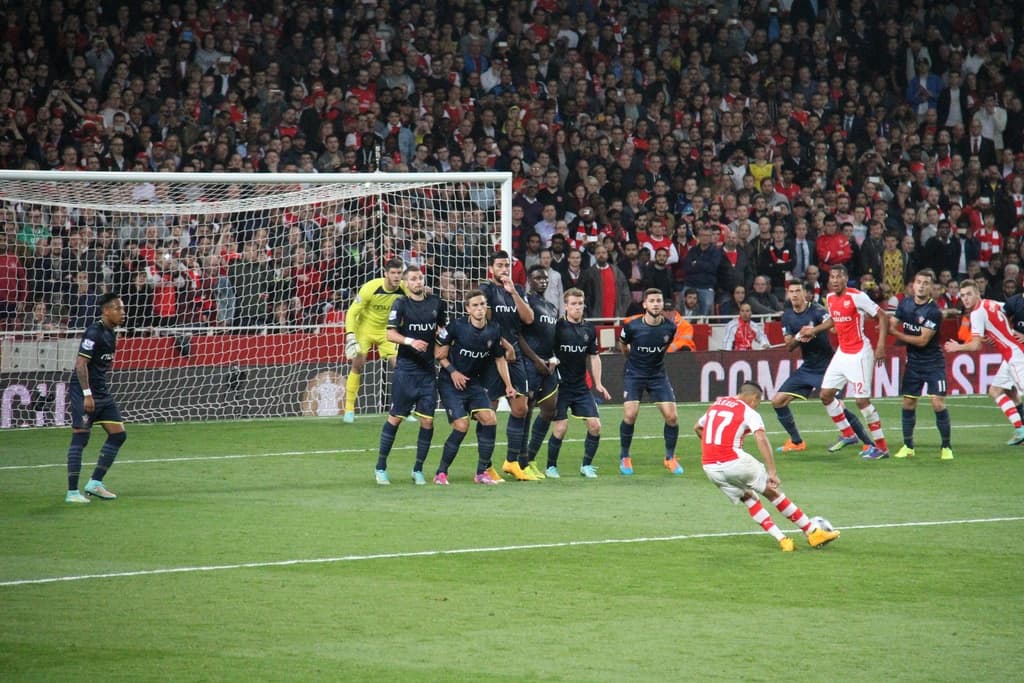 Fussballspieler auf einem Feld mit einer groÃen Menge im Hintergrund.