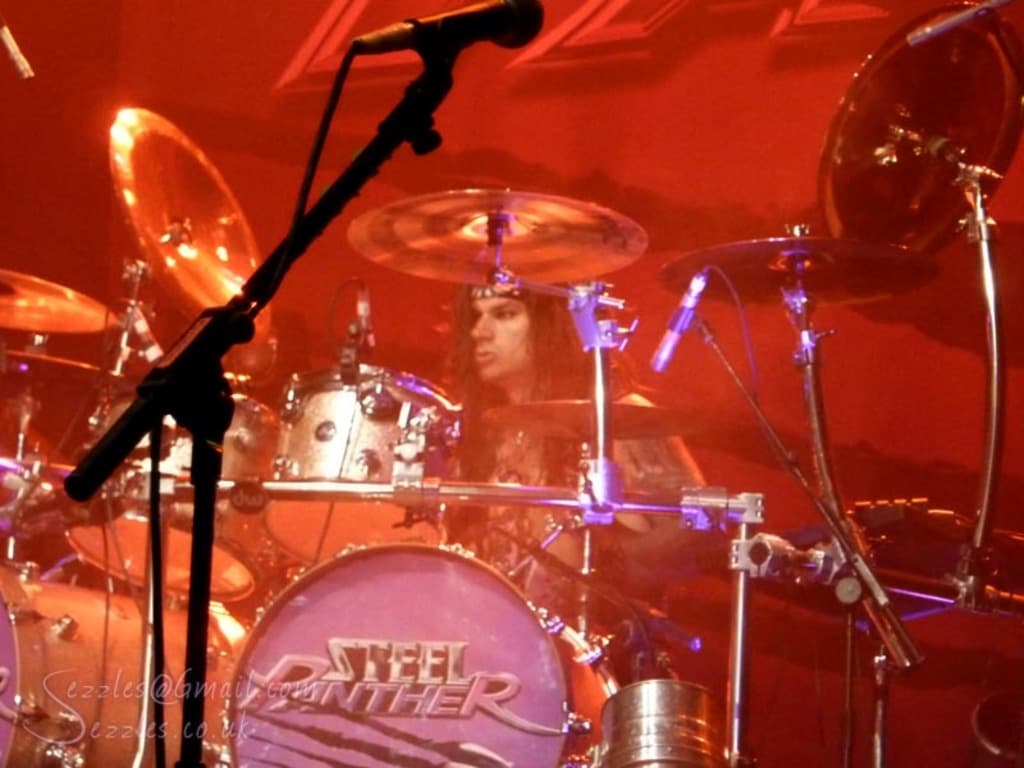 Eine Musikband spielt mit einem Musiker, der von konzentriertem rotem Licht umgeben ist.