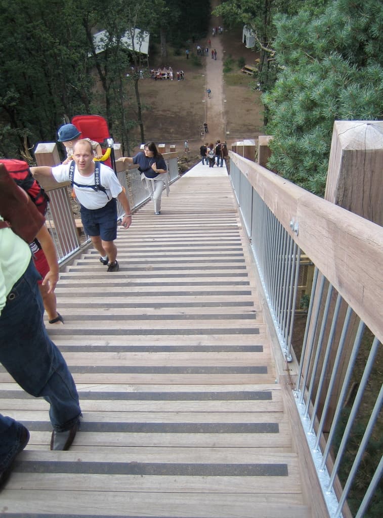 Eine Gruppe von Menschen versammelt sich unter dem Sternenhimmel mit Zelten, Bänken und Bäumen im Hintergrund.