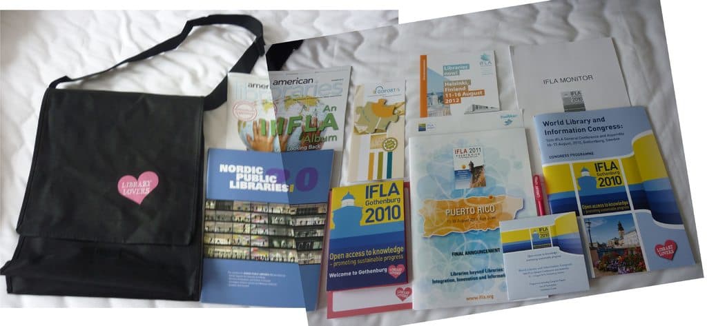 Eine Tasche mit "Bibliothek-Liebhaber" darauf und einige Bücher auf einem Bett.