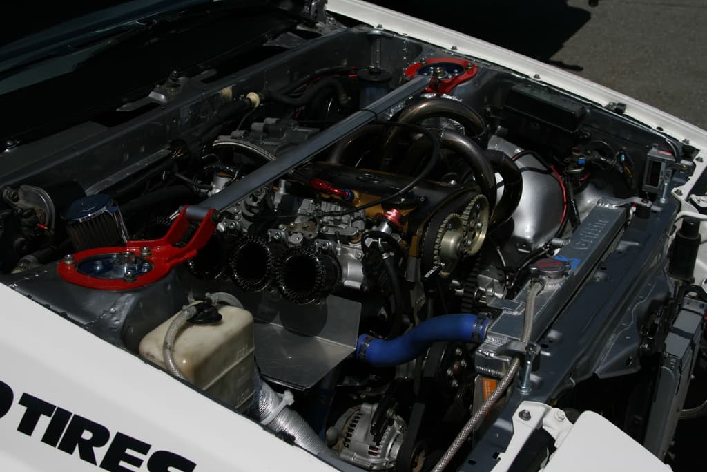 Ein Auto-Motor mit sichtbaren Rohren und einer Batterie.