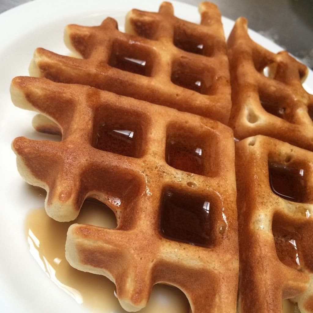 Ein Waffel-Nachtisch wird auf einem Teller präsentiert.
