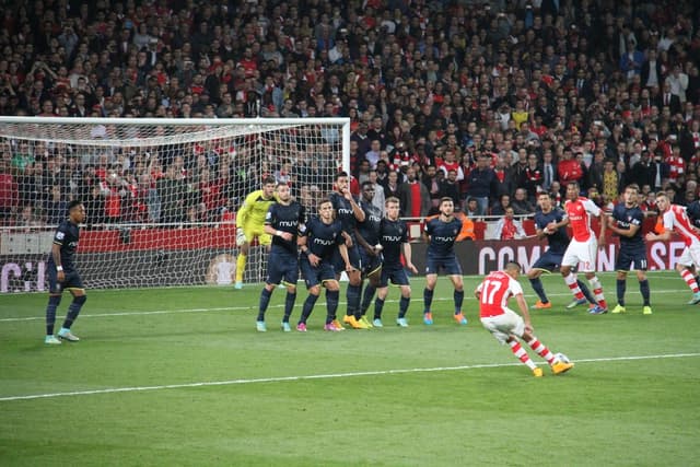 Fußballspieler auf einem Feld mit einer großen Menge im Hintergrund.