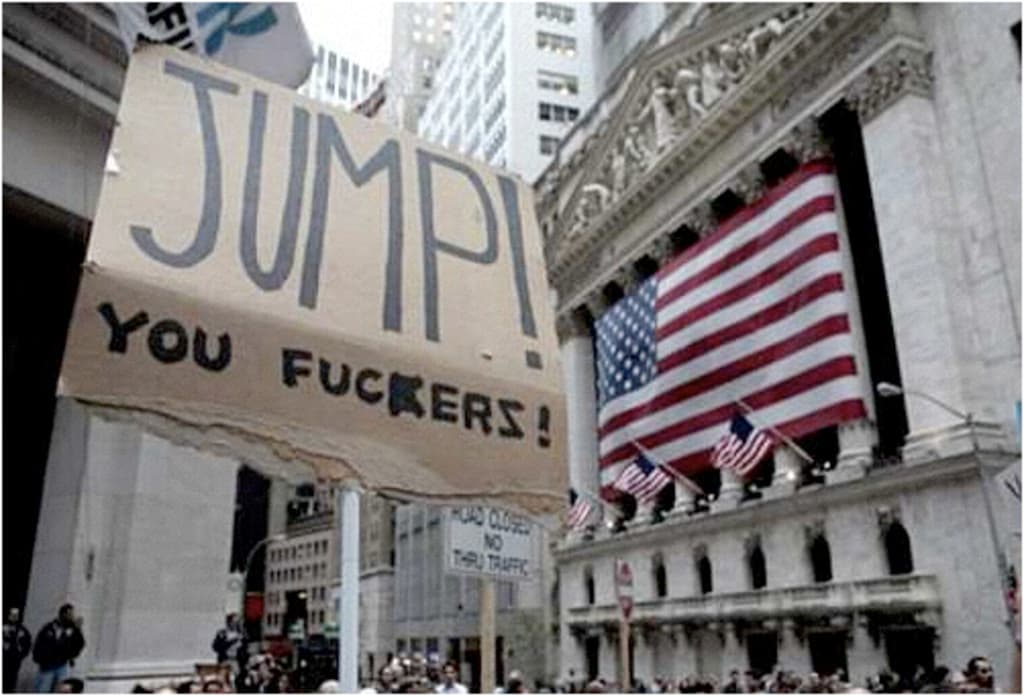 Eine große Menschenmenge mit Schildern und Plakaten, mit sichtbaren US-Flaggen und Gebäuden im Hintergrund.