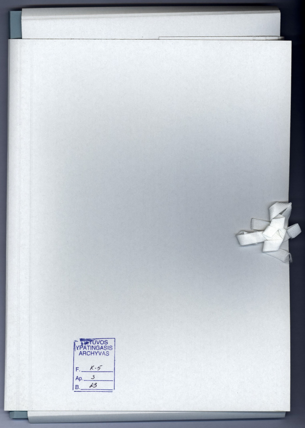 Ein weißer Ordner mit einer weißen Schleife drumherum, der Text zeigt, auf einer grauen Oberfläche.