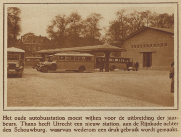 Ein altes Foto eines Busbahnhofs mit mehreren geparkten Bussen, Menschen drumherum und Bäumen und Gebäuden im Hintergrund, mit Text am unteren Bildrand.