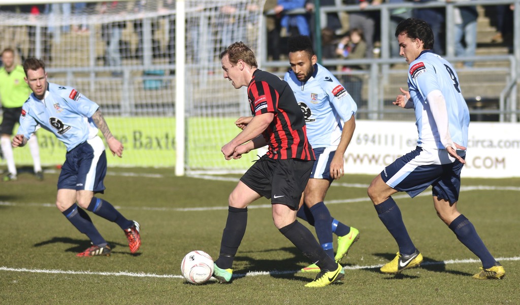 Eine Gruppe von Menschen spielt mit einem Fußball auf einem Feld.