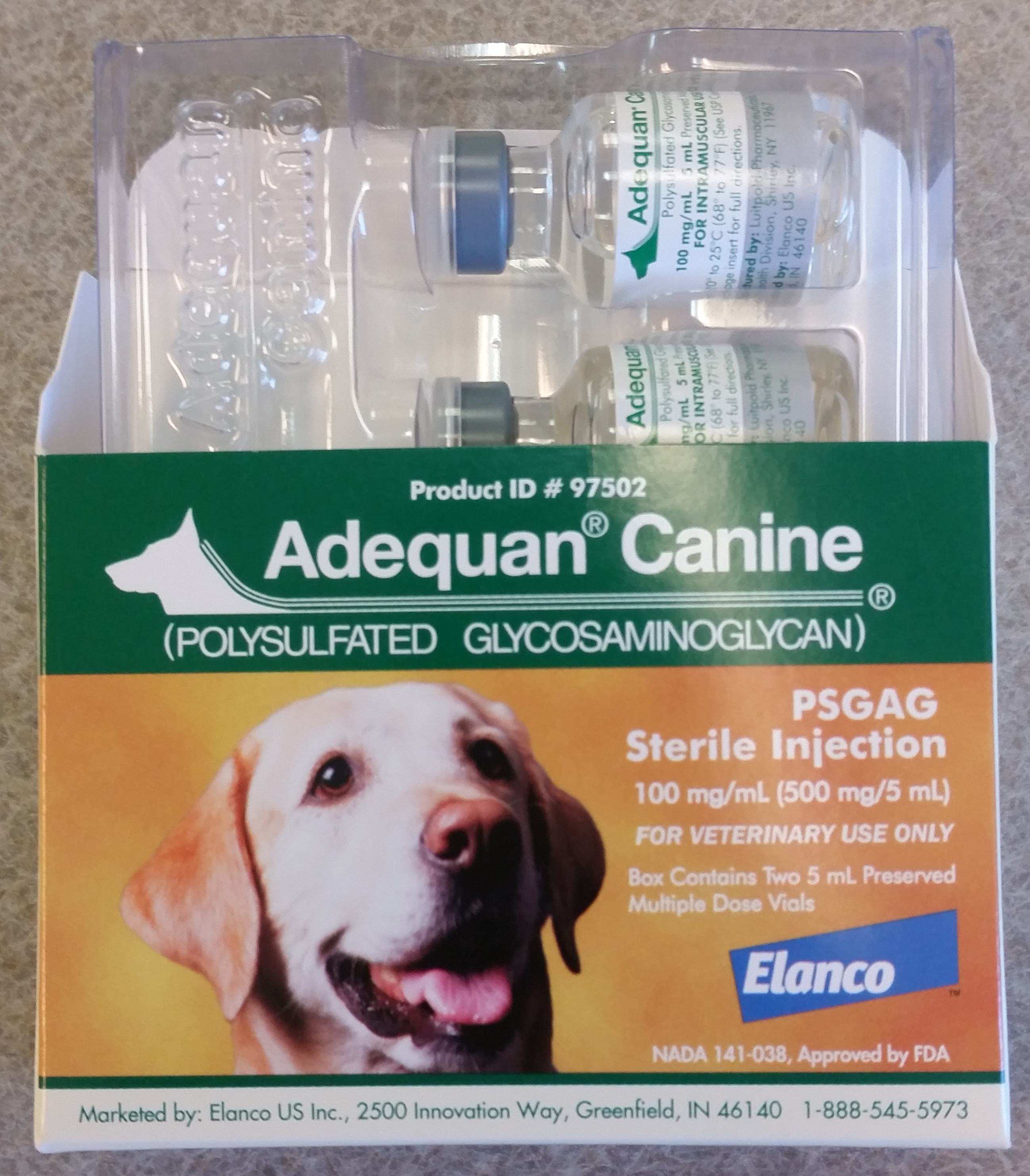 Eine Schachtel Adequan Canine Polysulfated Glycosaminoglycan Sterile Injection, die ein Hundebild und Produktbeschreibungstext zeigt, auf einer flachen Oberfläche platziert.