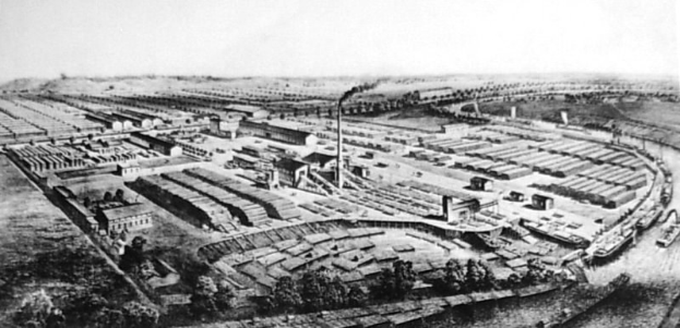 Luftaufnahme in Schwarz-Weiß von einer dichten Stadt mit zahlreichen Gebäuden, Bäumen und einer Wasserfront.