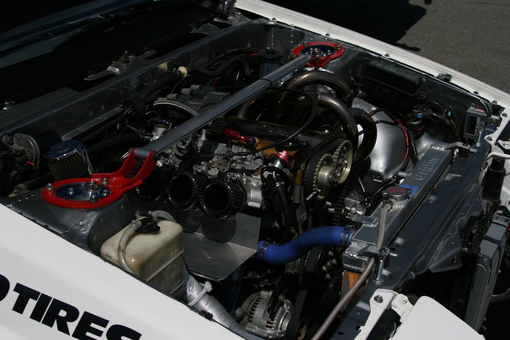 Ein Auto-Motor mit sichtbaren Rohren und einer Batterie.