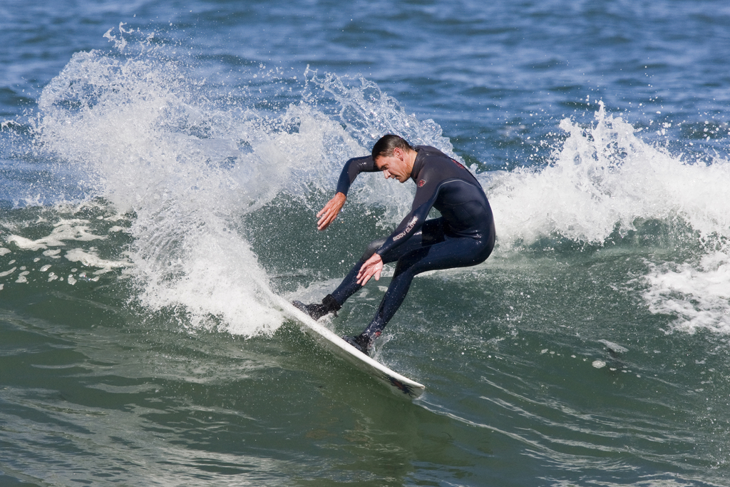 Eine Person steht auf einem Surfbrett im Wasser.