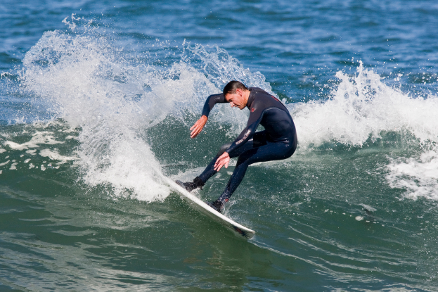 Eine Person steht auf einem Surfbrett im Wasser.