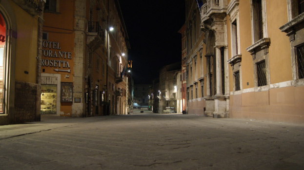 Eine Straßenszene mit Gebäuden auf beiden Seiten, einem Geschäft auf der linken Seite und Lichtern in der Mitte.