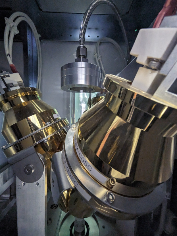 CNC-Fräsmaschine in einer Fabrik mit einem Metallobjekt im Vordergrund und einer Wand im Hintergrund, mit verbundenen Werkzeugen und Komponenten.