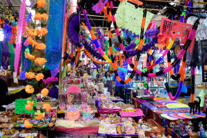 Ein belebter Markt mit Ständen, die Spielzeug, Dekorationsartikel und andere Gegenstände verkaufen, unter Deckenbeleuchtung mit Menschen, die durchschlendern.