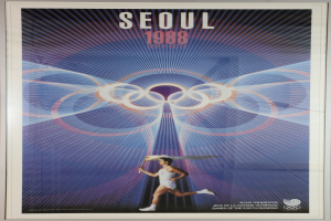 Eine Person, die mit den Olympischen Ringen im Hintergrund und der Aufschrift "Olympische Spiele" läuft und die Olympischen Spiele 1988 in Seoul, Südkorea, bewirbt.