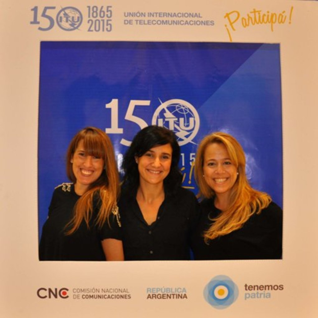 Ein Foto mit drei Frauen auf einem blauen Hintergrund, umgeben von den Namen verschiedener Sponsoren und einem Unternehmensnamen.