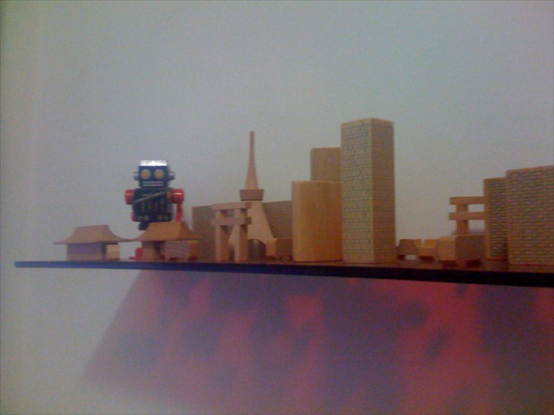 Eine Vielfalt an Spielzeugen ist auf einem Holzregal angeordnet.