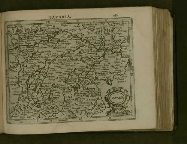 Offenes Buch mit einer detaillierten Karte von Bayern, einschließlich Städte und Ortschaften, mit begleitendem Text, der die Region beschreibt.