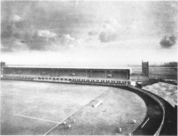 Schwarzes und weißes Foto eines Fußballfeldes mit einem Stadion im Hintergrund, umgeben von Bäumen unter einem bewölkten Himmel, mit 'Stoke City Football Club'-Text unten.