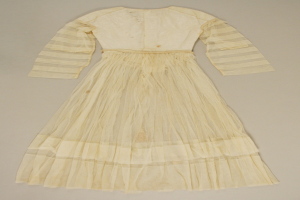 Ein weißes Langarmkleid mit einer gerüschten, voluminösen Röcke auf einer weißen Oberfläche, mit einem hohen Taillenbund, bodenlanger Saum und dezentem Schimmer.