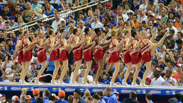 Mädels tanzen in der Mitte eines Bildes mit einer sitzenden Menge im Hintergrund.
