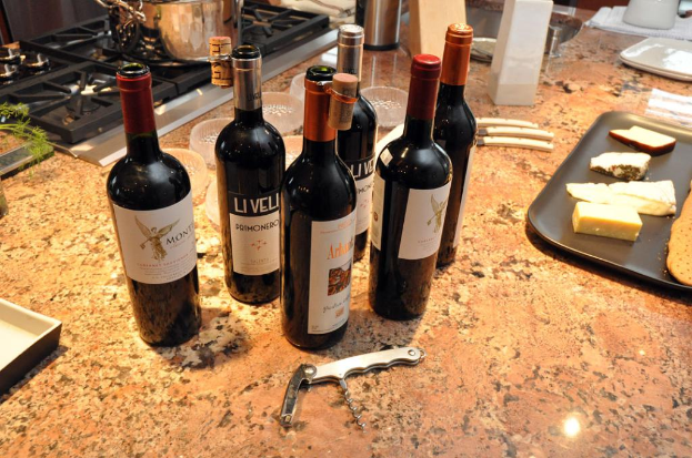 Eine Küchenplattform mit einem Topf auf dem Herd, Flaschen, ein Tablett mit Lebensmitteln, Messer, Schüsseln, eine Nagelschere und andere Gegenstände.