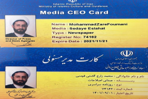 Eine Visitenkarte mit einem Mann in einem marineblauen Anzug, weißem Hemd und gemustertem Schlips, mit Urdu-Text und einem ernsten Gesichtsausdruck.