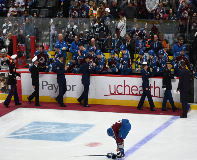 Ein Eishockeyspieler auf dem Eis umgeben von Fans und Teammitgliedern während eines Spiels der Colorado Avalanche gegen die San Jose Sharks am 24. März 2015.