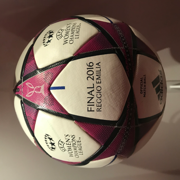 Ein Fußball auf einem weißen Tisch mit der Aufschrift "UEFA Women's Champions League Final 2016" in Weiß, Rosa und Schwarz.
