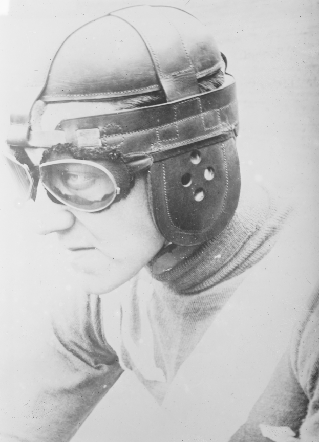 Ein Mann in einem Helm und einer Schutzbrille schaut ernst in die Ferne in einem alten Schwarz-Weiß-Foto.