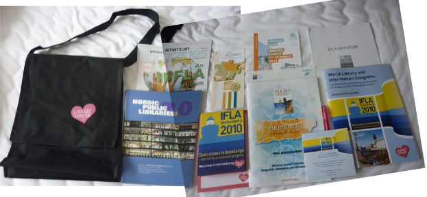 Eine Tasche mit 'Library Lovers' drauf und einige Bücher auf einem Bett.