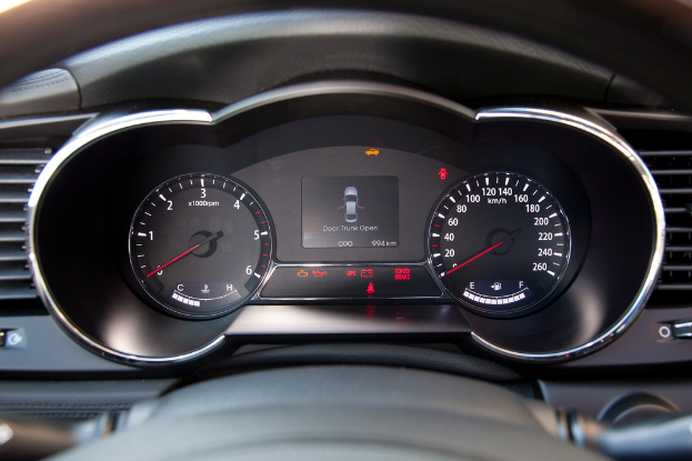 Ein Close-up eines Autos mit verschiedenen Armaturen, auf dem ein kleines Auto auf dem Bildschirm zu sehen ist.