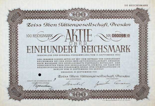 Altes deutsches Aktienzertifikat mit der Aufschrift "Aktie über Einhundert Reichmark", das einen Wert von 100 Reichmark angibt, mit schwarzem Rand und gedrucktem Text.
