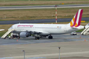 Ein Airbus A320-200 der Germanwings steht am Frankfurter Flughafen, mit Fahrzeugen, Verkehrskegeln, Pfählen und Gras im Hintergrund.
