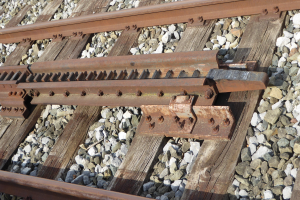 Nahaufnahme einer Schienenstrecke aus Metallschienen und Steinen.