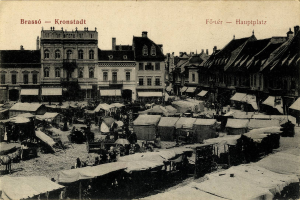 Ein Schwarz-Weiß-Foto eines belebten Marktes in Kronstadt, Deutschland, mit Menschen, Zelten und Gebäuden mit Fenstern im Hintergrund und Text auf dem Bild.