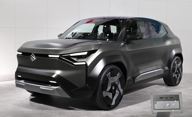 Ein schlankes, glänzend schwarzes Suzuki EVX Concept-Auto mit einem großen Kühlergrill und einer gebogenen Motorhaube auf der Frankfurt Motor Show ausgestellt, mit einer Tafel im Vordergrund und einer Wand im Hintergrund.