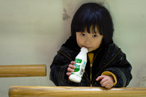 Ein Kind mit einer Flasche in der Hand.
