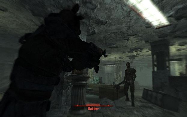 Das Innere eines Gebäudes mit Skulpturen, einer Leuchte und einem gerahmten Kunstwerk an der Wand.