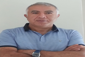 Ein Mann in einem blauen T-Shirt mit verschränkten Armen steht vor einer weißen Wand, mit Text unten, der ihn als den neu ernannten Marketingchef identifiziert.