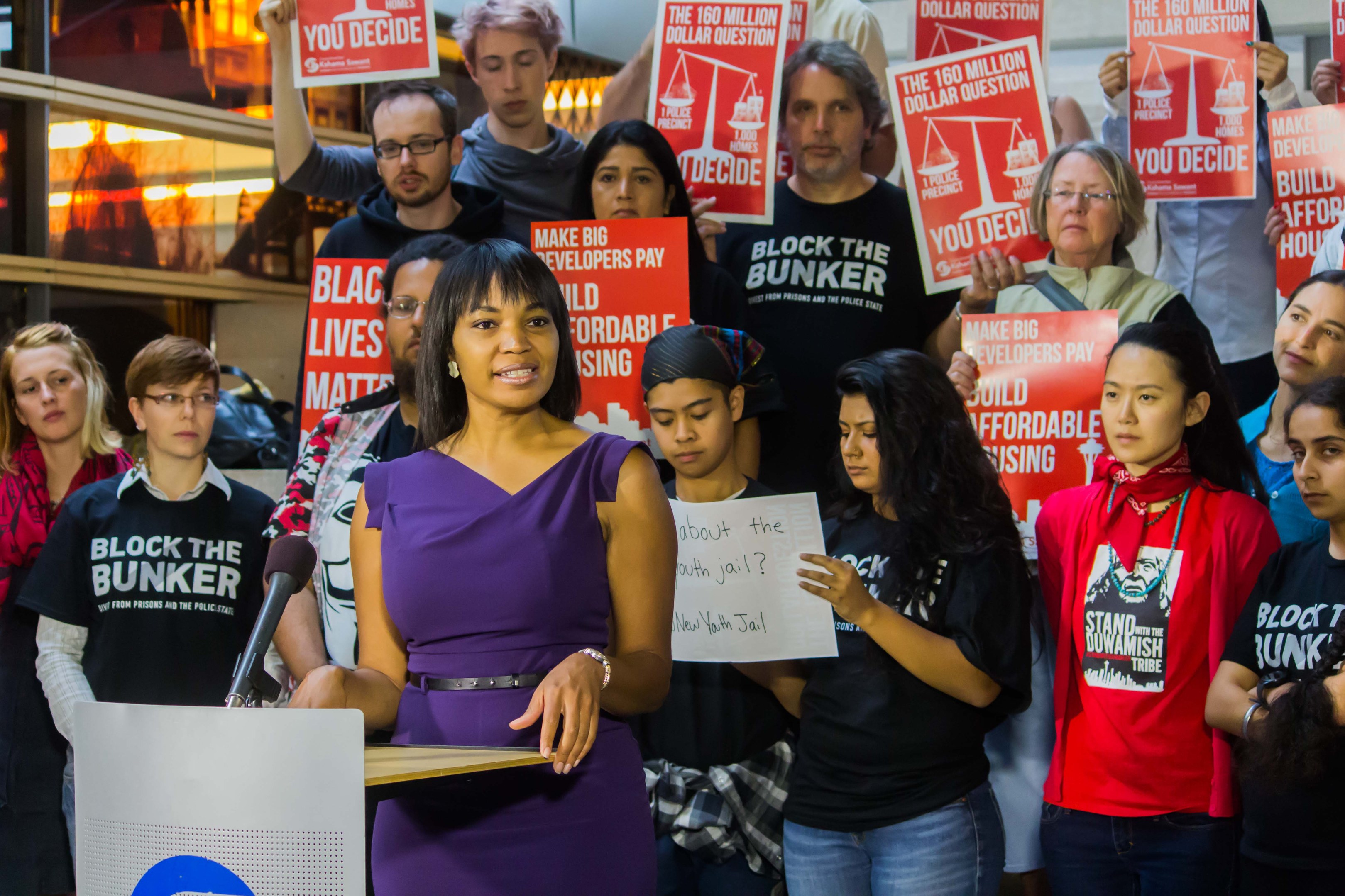 Eine Black-Lives-Matter-Aktivistin spricht vor einem Publikum mit Mikrofon.