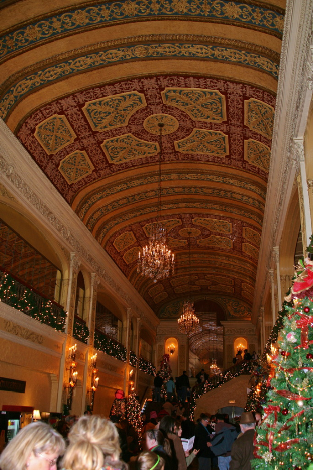 Eine Gruppe von Menschen steht zwischen Pflanzen mit Lichtern und Lampen an der Decke.